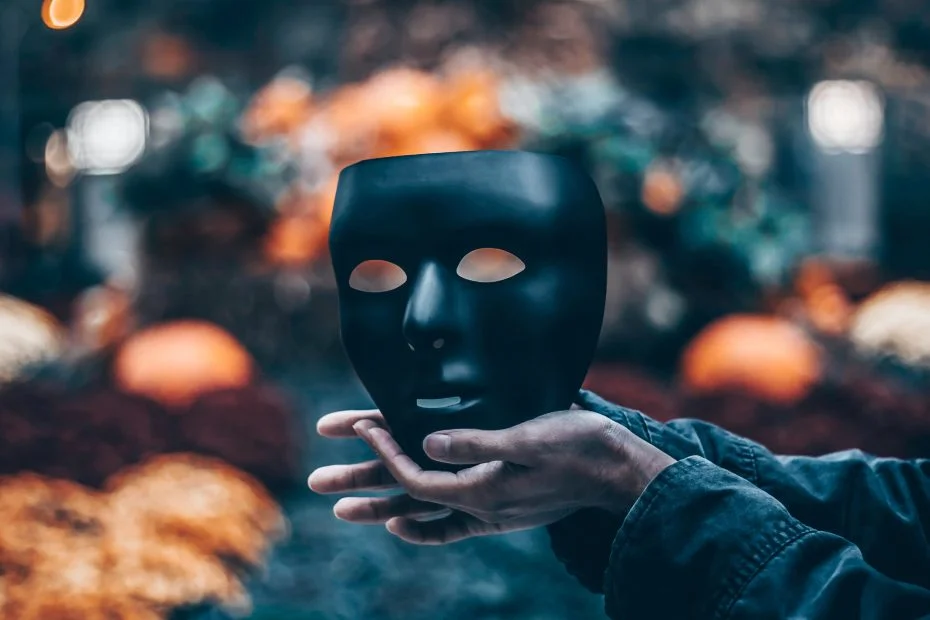 Hands holding a black face mask