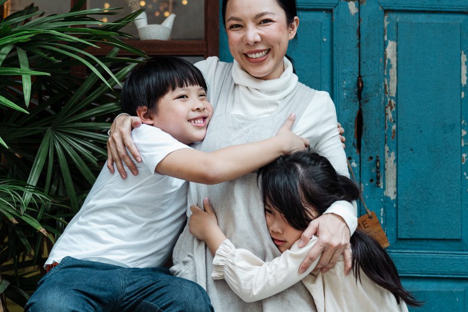 Smiling woman hugging two children