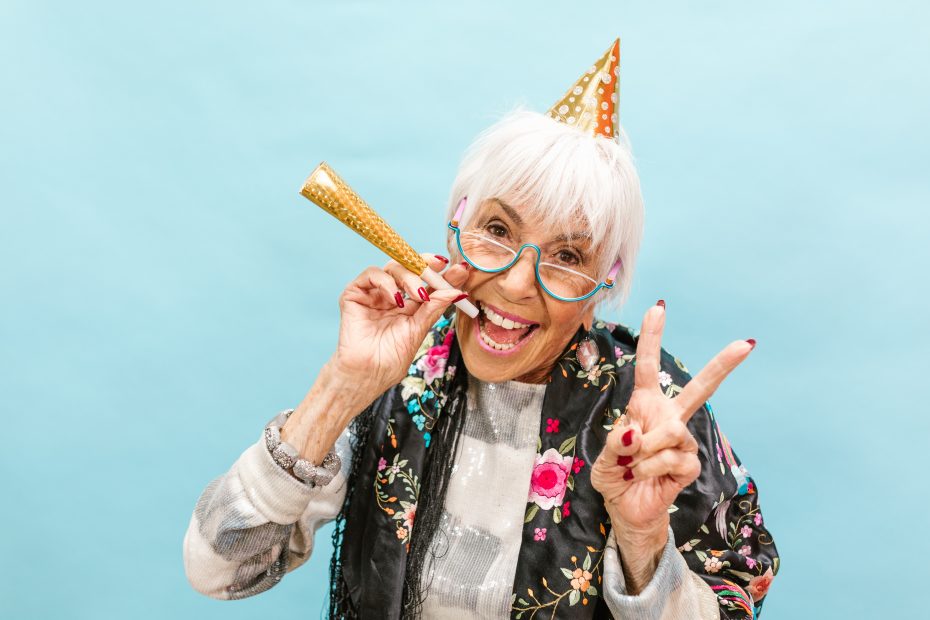 White-haired woman in celebratory outfit.