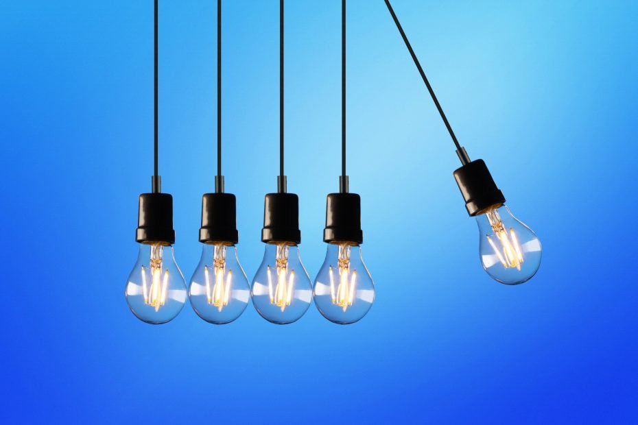 Five hanging light bulbs in front of a blue background