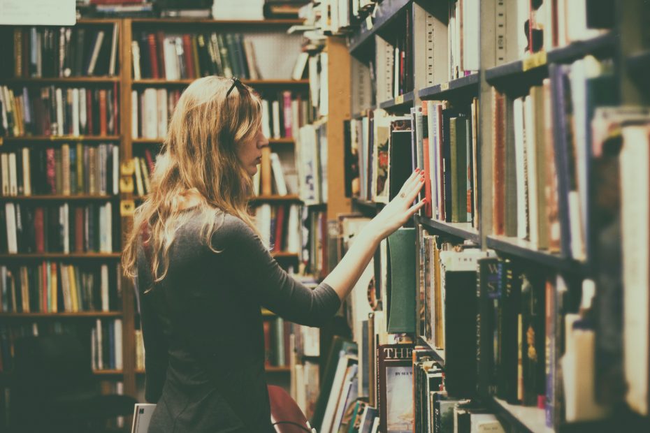 Woman browsing looking at books inside a library